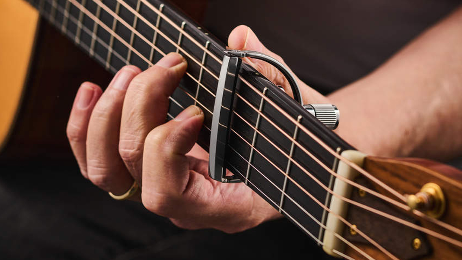Close up of a capo on an acoustic guitar