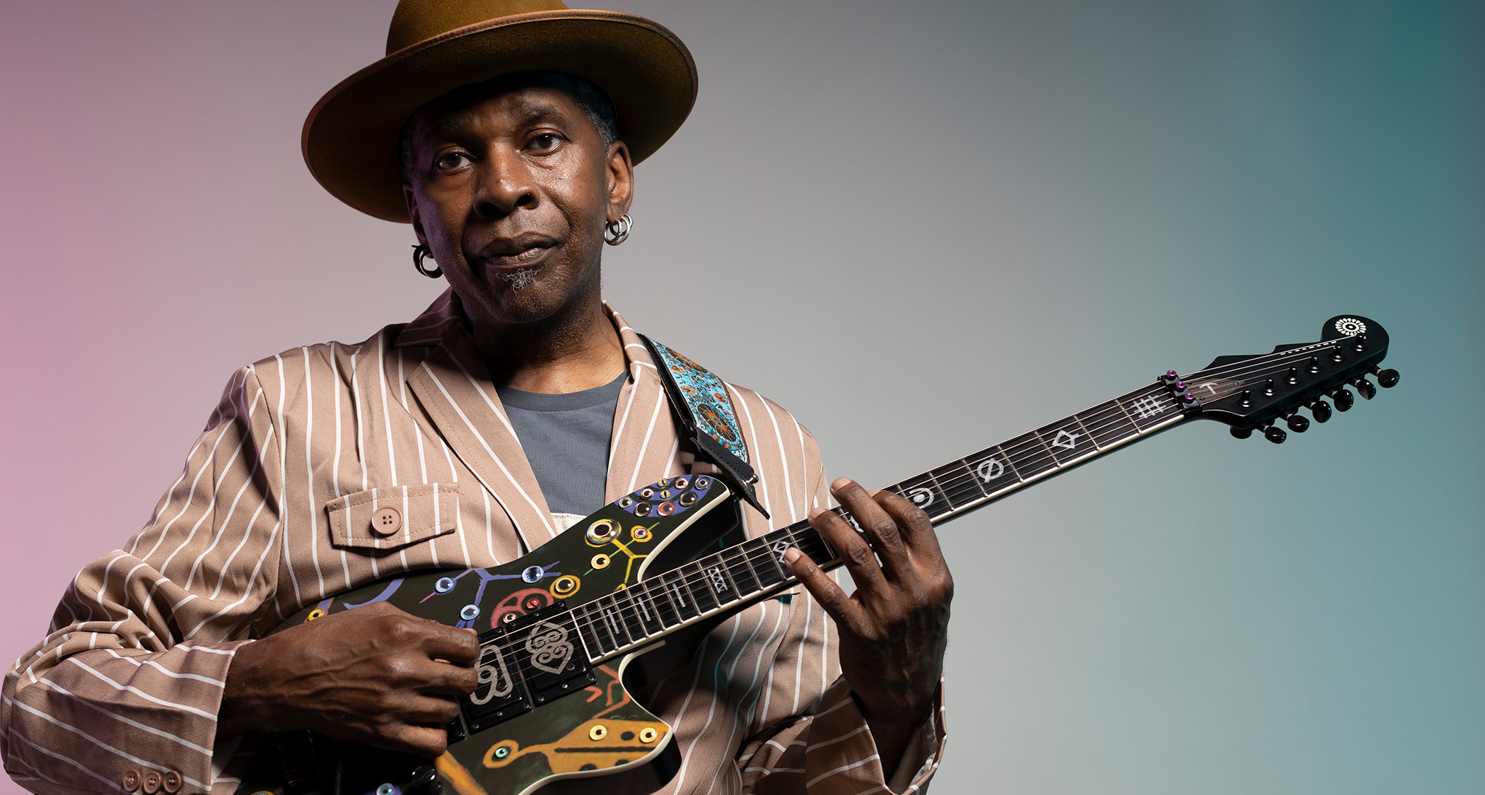 A portrait of Vernon Reid wearing his now trademark hat with his Reverend signature guitar
