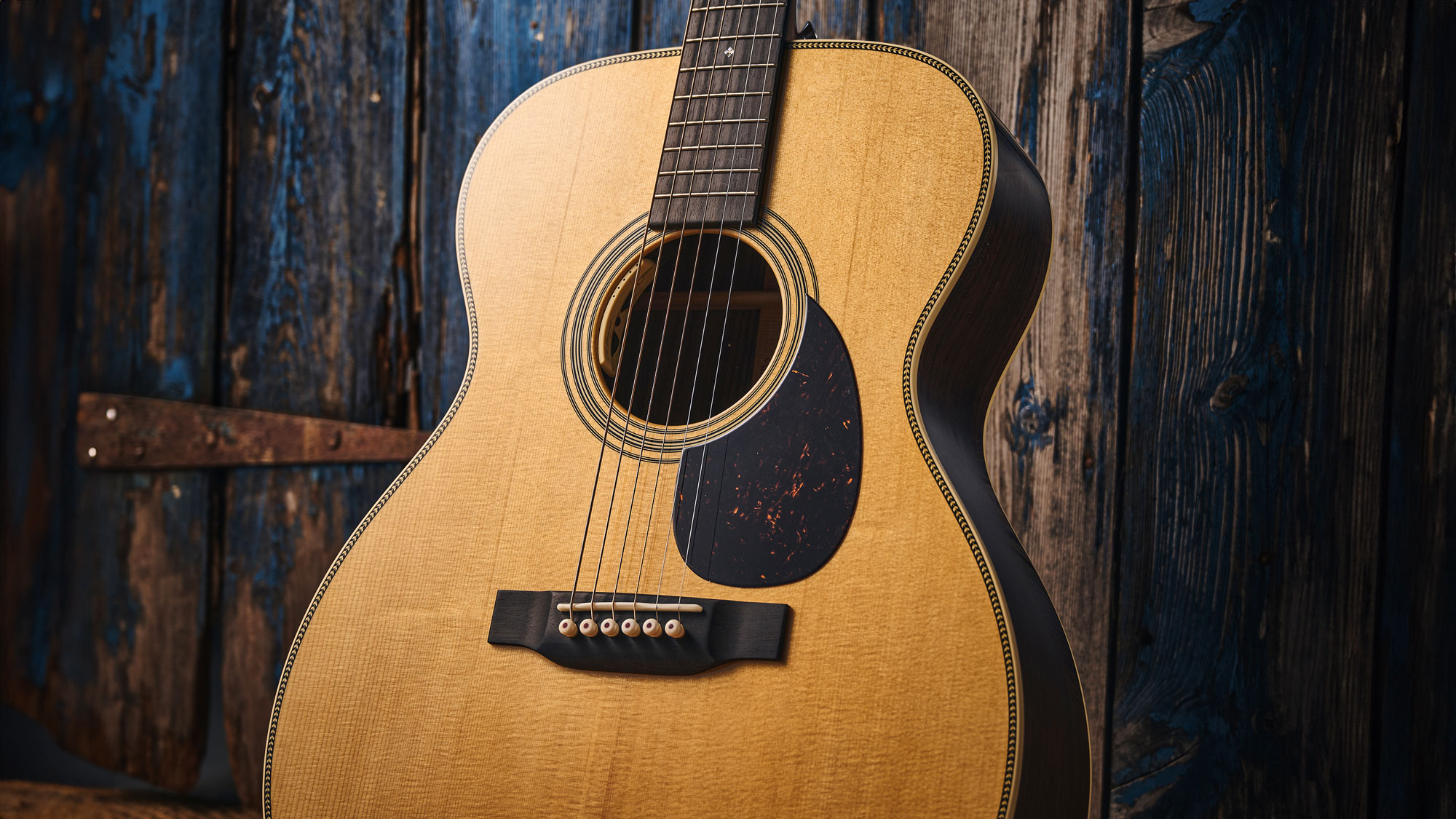 Martin OM-28E with L.R. Baggs Anthem is a stunning update on a classic acoustic, with top-class electronics. Here it is photographed in close-up and against a door with a distressed blue paint-job.